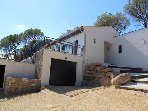a white house with a garage and a balcony at State of the Art Fixtures Villa in Vidauban with Pool in Vidauban