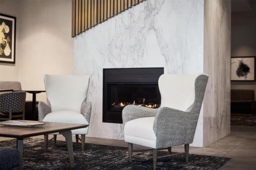 two chairs and a table in front of a fireplace at Hyatt Place Salt Lake City Downtown / The Gateway in Salt Lake City