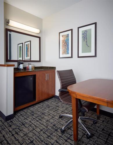 a hotel room with a desk and a table and chairs at Hyatt Place Salt Lake City Downtown / The Gateway in Salt Lake City