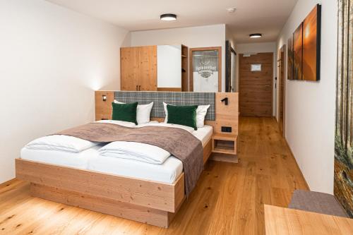 a bedroom with a large bed with green pillows at Hotel Spinnerhof in Sasbachwalden