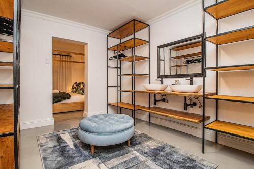 a dressing room with a blue ottoman and shelves at The Otters Oarsman Stanford Riverside Retreat in Stanford