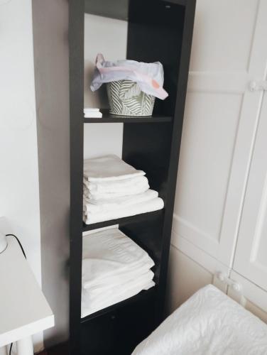 a black shelf with folded towels in a bedroom at Bed in mixed dorm ideal for bikes and walkers on the camino Pilgrim passport holders only in Zizur Mayor