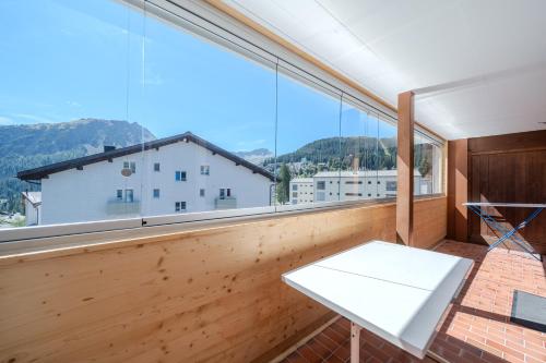 a room with a large window with a white table at Latschüel by Arosa Vacations, Familienwohnung im Zentrum mit Privatparkplatz in Arosa