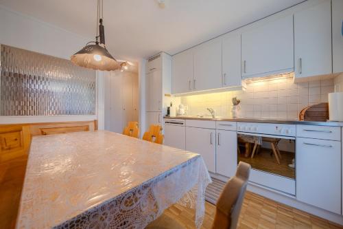 a kitchen with a table and a dining room at Latschüel by Arosa Vacations, Familienwohnung im Zentrum mit Privatparkplatz in Arosa