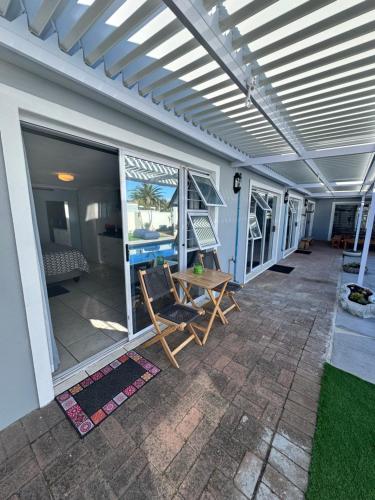 a patio with a table and chairs on a house at Pemba Guest Cape Town in Cape Town