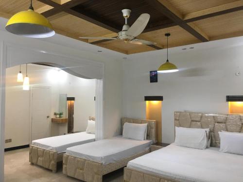 a bedroom with two beds and a ceiling fan at SJ Rezidor Guest House in Islamabad