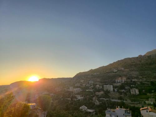 a view of the sun setting over a city at Faraya Vista in Kfardebian