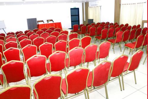 a row of red chairs in a conference room at Keerthy Palace Cherthala in Turavūr