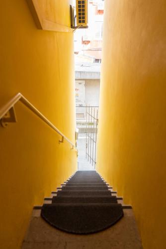 a stairway with yellow walls and yellow stairs at Tartini Residence - Fully Furnished Apartment in Piran