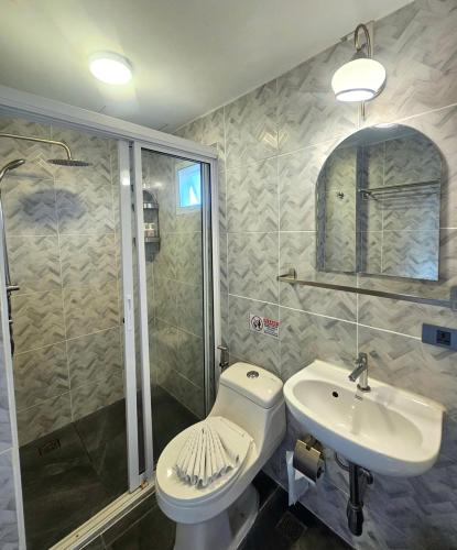 a bathroom with a toilet and a sink and a shower at Montree Phuket Hotel in Phuket Town