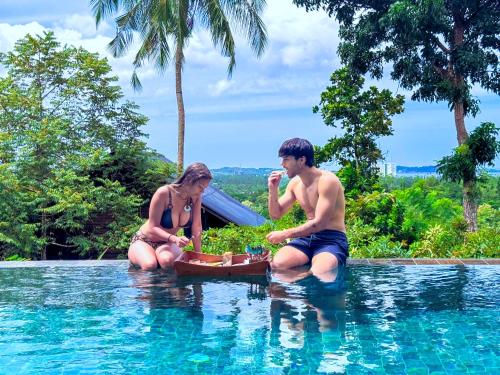 a man and a woman sitting in a swimming pool at Villa Hillcrest in Weligama