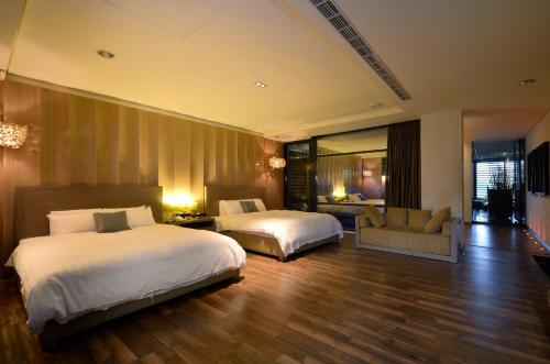 a hotel room with two beds and a couch at The Sun Hot Spring & Resort in Taichung