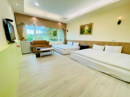 a hotel room with two beds and a television at 悅庭民宿 in Zhixue