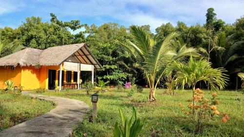 a small house in a field next to a path at Lekker Gezellig Dive Resort Manado in Bunaken