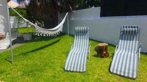 two chairs in a yard next to a hammock at Casa Teresinha in Sesimbra