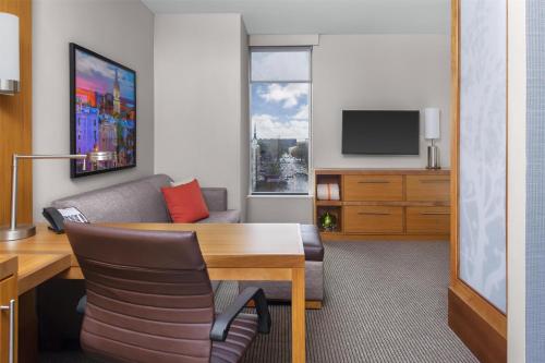a living room with a table and a couch at Hyatt Place Athens Downtown in Athens