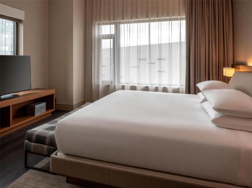 a bedroom with a large white bed and a television at Hyatt Regency Lake Washington at Seattle's Southport in Renton