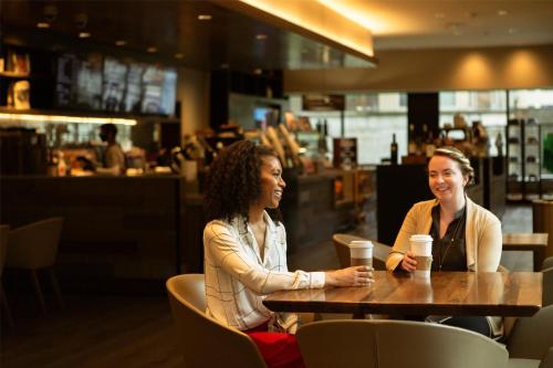 two women sitting at a table in a restaurant at Hyatt Regency Lake Washington at Seattle's Southport in Renton