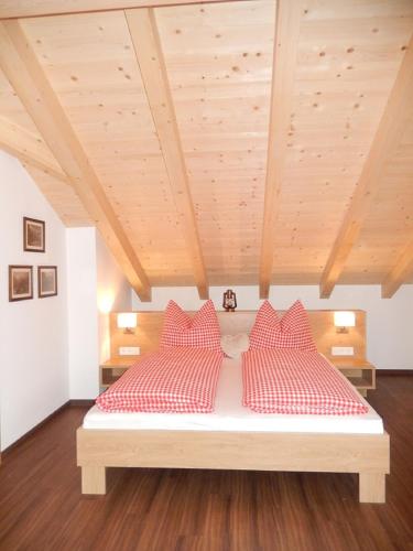 a bedroom with a bed with red and white pillows at ff Appartements in Bramberg am Wildkogel