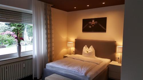 a bedroom with a bed and a window at Design Apartment nähe Düsseldorf in Krefeld