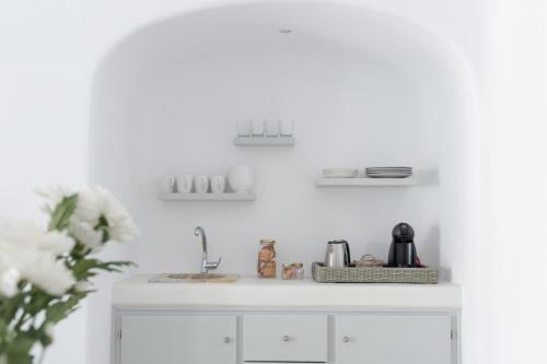 a white kitchen with a sink and a counter at Sensation Villa - by Senses Collection in Pirgos