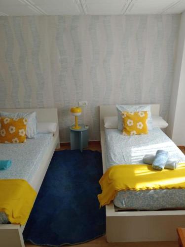 a bedroom with two beds with yellow and blue at Casa de Pueblo in Martos