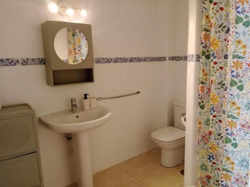 a bathroom with a sink and a toilet and a mirror at Casa de Pueblo in Martos