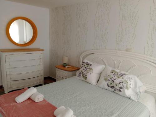 a bedroom with a white bed and a mirror at Casa de Pueblo in Martos