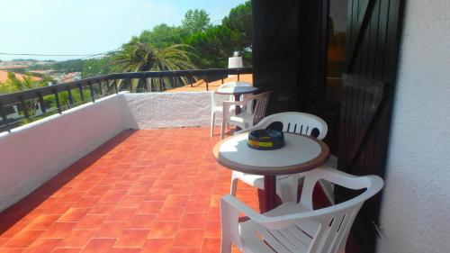 a patio with two tables and chairs on a balcony at Casa Teresinha in Sesimbra