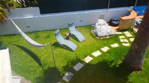 two chairs and a hammock in a yard at Casa Teresinha in Sesimbra