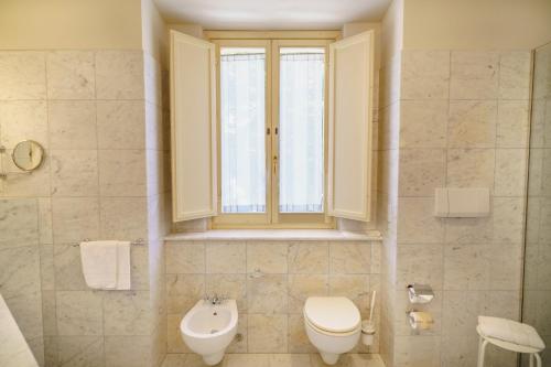 a bathroom with a toilet and a window at Hotel San Luca in Spoleto