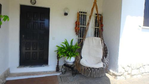 a hammock hanging next to a door with a plant at Casa Teresinha in Sesimbra