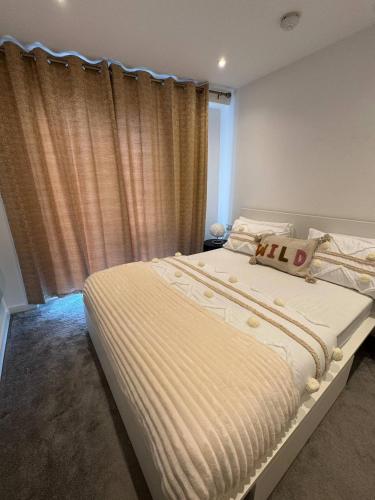 a bedroom with a large white bed with a window at Exquisite Riverview 2bedroom flat in Manchester. in Manchester