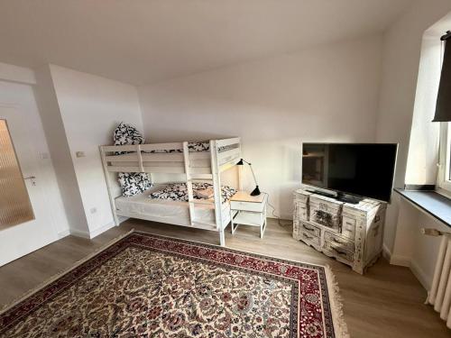 a bedroom with a bunk bed and a flat screen tv at Wu Stay in Wuppertal