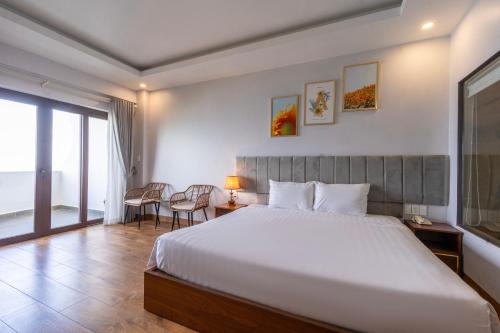 a bedroom with a bed and a table and chairs at Maris Beach Hotel Phu Quoc in Phu Quoc
