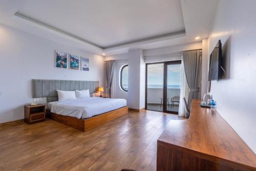a bedroom with a bed and a television in it at Maris Beach Hotel Phu Quoc in Phu Quoc