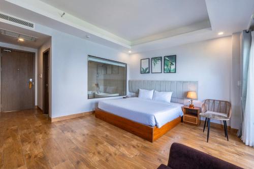 a bedroom with a bed and a desk and a chair at Maris Beach Hotel Phu Quoc in Phu Quoc