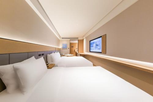 Ένα ή περισσότερα κρεβάτια σε δωμάτιο στο JI Hotel Beijing Headquarters Base Guogongzhuang Subway Station