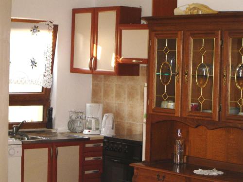 a kitchen with wooden cabinets and a counter top at Holiday Home Sisan near Beach & Pool in Šišan