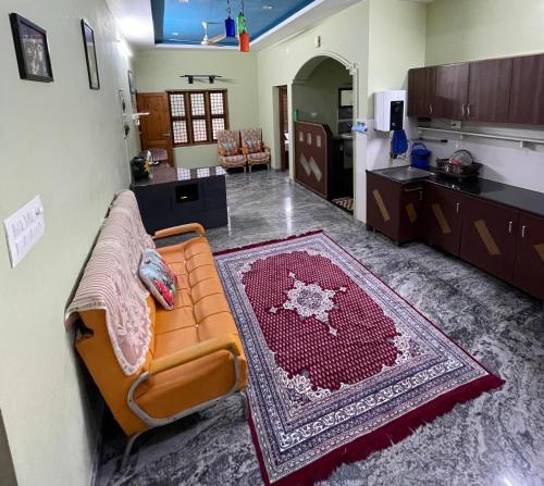 a living room with a couch and a kitchen at Gurukripa Homestay in Kānnangād