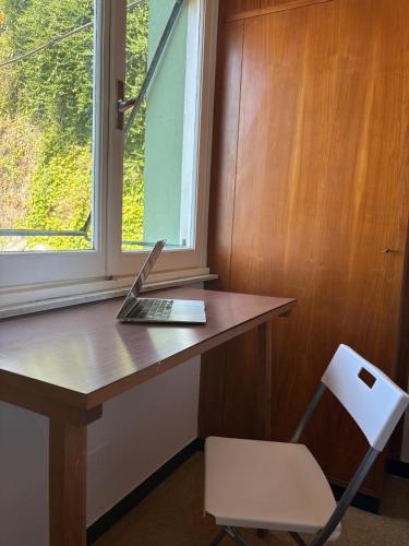 a laptop computer sitting on a wooden desk next to a window at Il terrazzino sul Golfo in Recco
