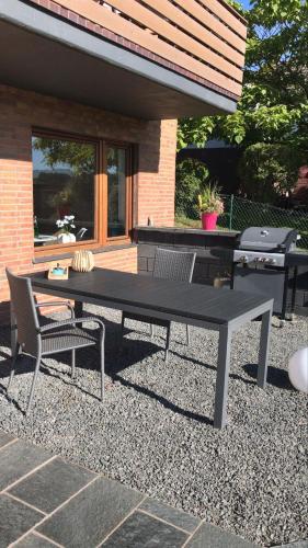 a picnic table and two chairs and a grill at Ferienwohnung Empt Vussem in Mechernich