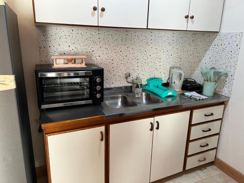 a kitchen counter with a sink and a microwave at El Depa 5 - Cerca de todo- in Eldorado