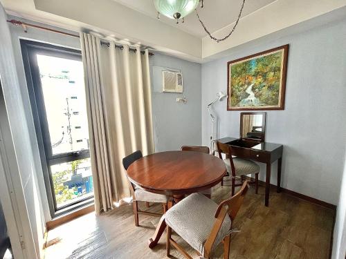 a dining room with a wooden table and a desk at CEO Flats in Manila