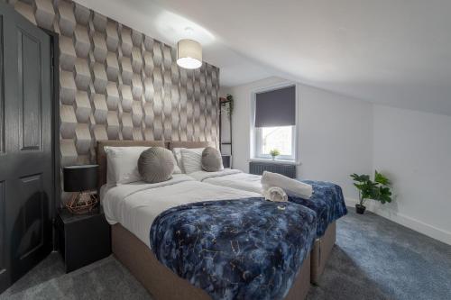 a bedroom with a large bed with a blue blanket at 5 Bed Workington House with Parking Near Station in Workington