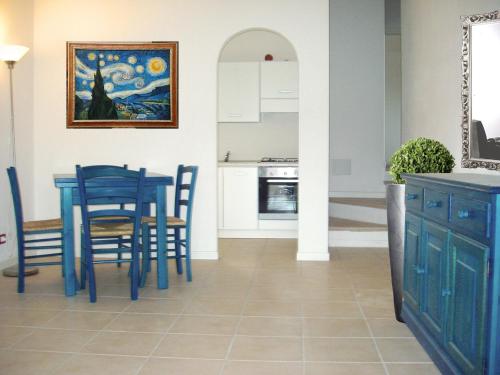 a kitchen and dining room with a blue table and chairs at elegant apartment near the beach of Baja Sardinia in Baraccamenti