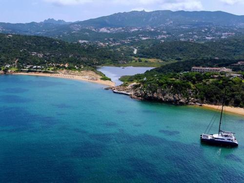 a boat in the water next to a beach at elegant apartment near the beach of Baja Sardinia in Baraccamenti