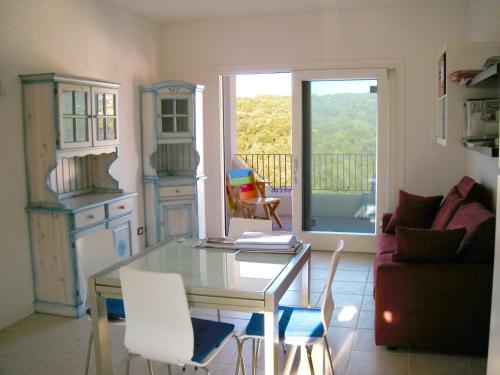 a living room with a glass table and white chairs at elegant apartment near the beach of Baja Sardinia in Baraccamenti