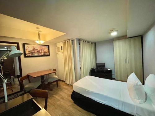 a hotel room with a bed and a desk at CEO Flats in Manila