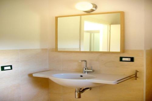 a bathroom with a white sink and a mirror at elegant apartment near the beach of Baja Sardinia in Baraccamenti